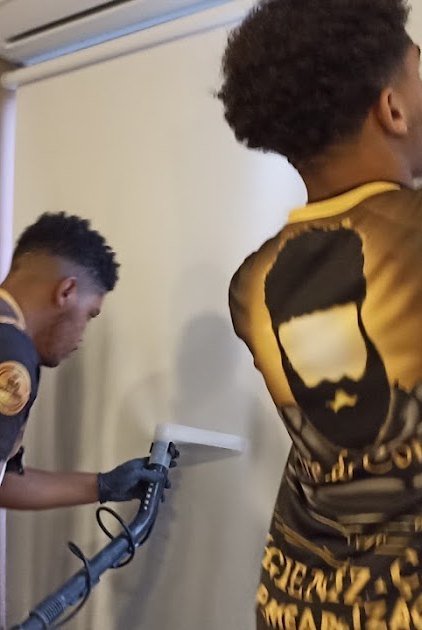 Equipe higienizando cadeiras em uma sala de reunião